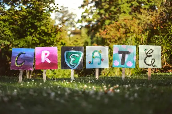 painted signs with the word create in a grassy field. painted signs with the word create in a grassy field.